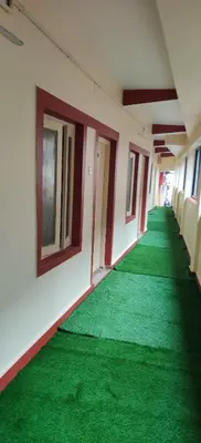 an empty hallway with green carpet in a building at Hotelsapphire in Ooty