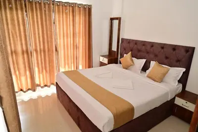 a bedroom with a large bed in a room at Oasis Service Apartments in Mysore