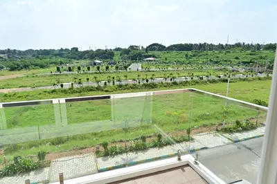 a view of a field from the window of a house at Oasis Service Apartments in Mysore