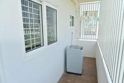 a hallway with two windows and a trash can at Oasis Service Apartments in Mysore
