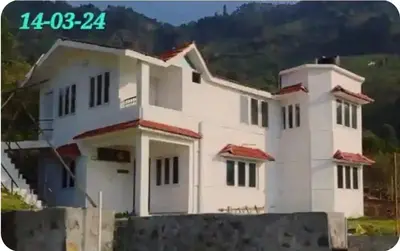 a white house with a hill in the background at NectorNest in Kodaikānāl
