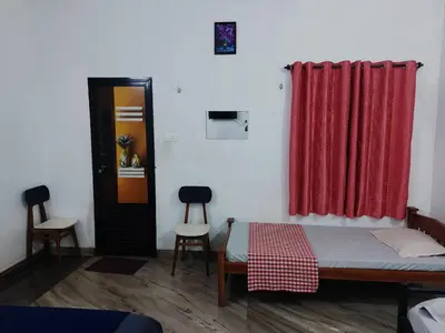 a room with a bed and a red curtain at Fathima Arcade Lodge