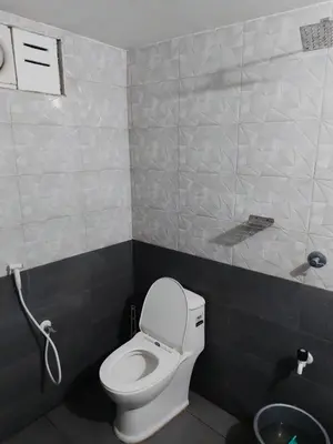 a small bathroom with a toilet and a shower at Fathima Arcade Lodge