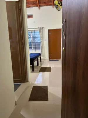 a hallway with a door leading to a living room at River point homestay in Kushālnagar