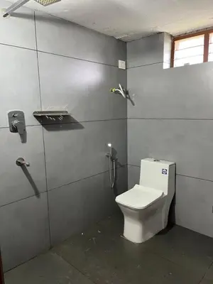 a bathroom with a white toilet in a stall at Dragster Homes Alwaye in Alwaye