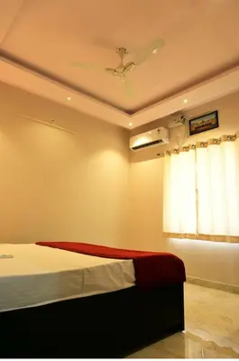a bedroom with a bed and a ceiling fan at PuMi Residence in Vānivilāsa Puram