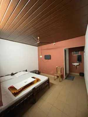 a bedroom with a large bed with a wooden ceiling at LunaBloom Stays in Marayoor