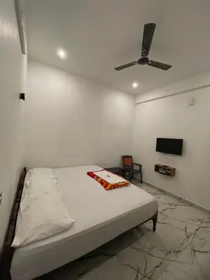 a bedroom with a bed and a ceiling fan at LunaBloom Stays in Marayoor