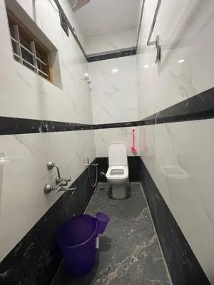 a bathroom with a toilet and a sink at LunaBloom Stays in Marayoor