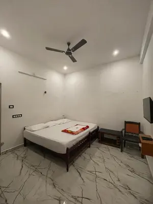 a bedroom with a bed and a ceiling fan at LunaBloom Stays in Marayoor
