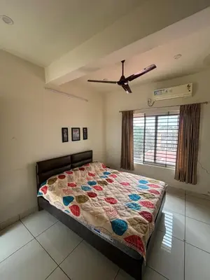 a bedroom with a bed and a ceiling fan at Falcon Heights in Mysore