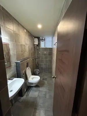 a bathroom with a toilet and a sink at Falcon Heights in Mysore
