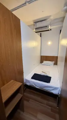 a small room with a white bed and a heater at Ith Pods & Dormitory in Kozhikode