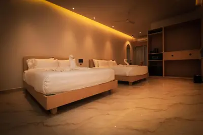 two beds in a hotel room with white sheets at Hotel Shellmark in Elivāla