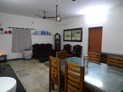 a living room with a glass table and chairs at Eden luxury stay saravanampatti in Coimbatore