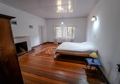 a bedroom with a bed and a fireplace at Arivikad Tea Bungalow Munnar By VOYE HOMES in Munnar