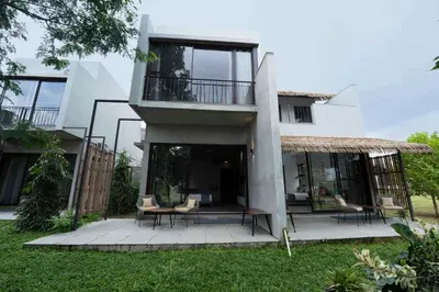 a white house with a balcony and some chairs at Wild Origin Kabini - A Luxury Resort in Kabini River