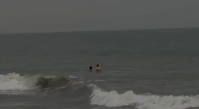 a couple of people in the water in the ocean at Seawind in Kannur