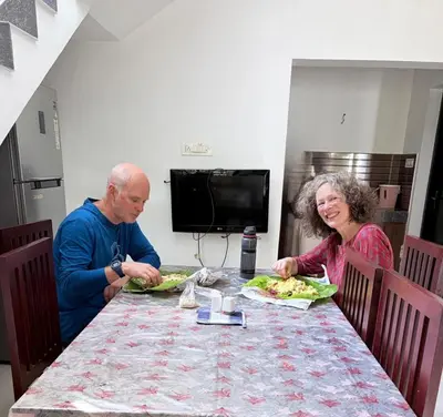 a man and a woman sitting at a table eating food at Seawind in Kannur