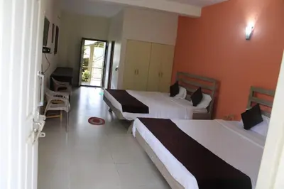 a hotel room with two beds and a balcony at Safari Inn in Kurchi