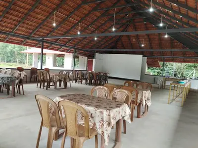 a group of tables and chairs in a room at Safari Inn in Kurchi