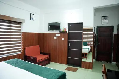 a bedroom with a bed and a chair and a cabinet at TREE 9 COCHIN AiRPORT HOTEL in Nedumbassery