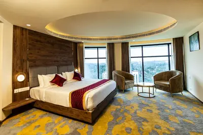 a hotel room with a bed and a large window at Ascot Hotel Calicut in Calicut