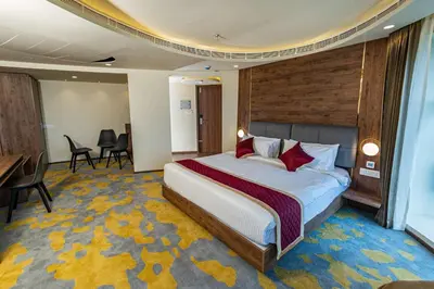 a hotel room with a bed and a desk at Ascot Hotel Calicut in Calicut