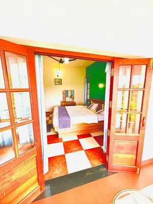 a bedroom with a bed and a large window at WAYANAD RESORT VILLA Service in Meppādi