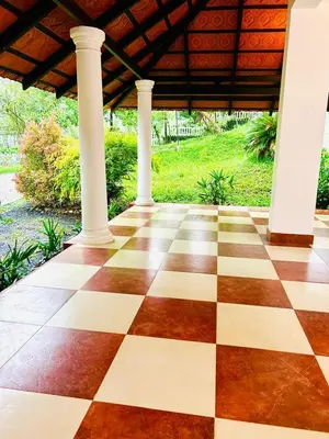a checkered floor in a building with columns at WAYANAD RESORT VILLA Service in Meppādi