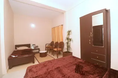 a bedroom with a bed and a desk and chairs at HIGHLAND Hills in Coonoor