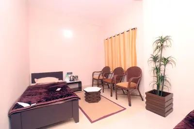 a bedroom with a bed and chairs and a table at HIGHLAND Hills in Coonoor