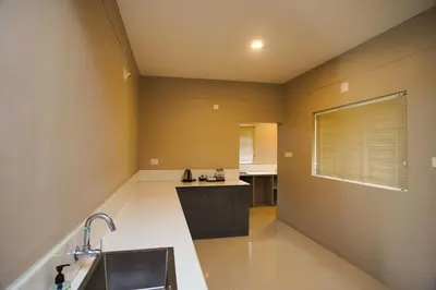 a large kitchen with a sink and a counter at Sreepathi Prayag 11 Service Apartment in Guruvāyūr