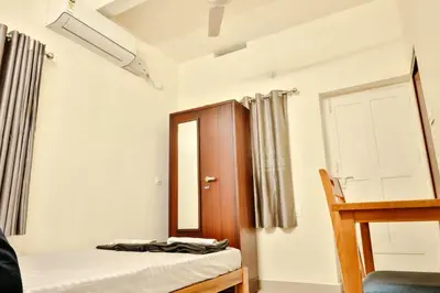 a bedroom with a bed and a mirror and a door at Nila Heavens - Spacious 5 BHK Homestay , ideal for families in Guruvāyūr