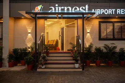a front entrance to a hotel with a sign on it at AIRNEST Airport Residency in Nedumbassery