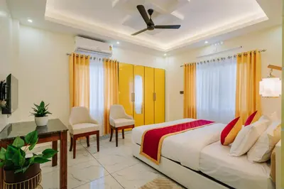a bedroom with a bed and a desk and chairs at AIRNEST Airport Residency in Nedumbassery
