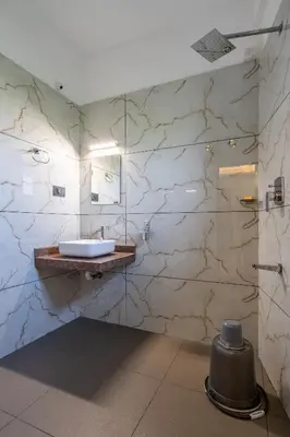 a bathroom with a sink and a mirror at AIRNEST Airport Residency in Nedumbassery
