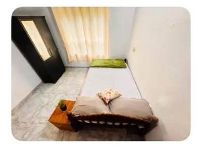 a room with two beds and a table and a window at Nirvana Stays Banasura, Wayanad in Wayanad