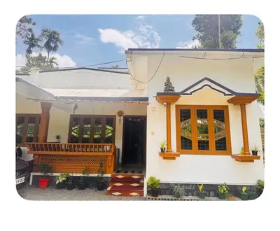 a small white house with a porch at Nirvana Stays Banasura, Wayanad in Wayanad