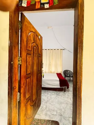 a door leading into a bedroom with a bed at Nirvana Stays Banasura, Wayanad in Wayanad