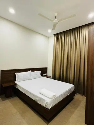 a bedroom with a bed and a curtain at Zainab in Kozhikode