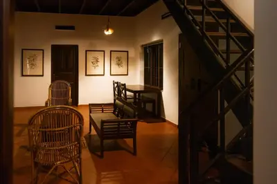 a room with chairs and a table and a staircase at Seethavanam Farmstay at Forest Edge in Kollengode