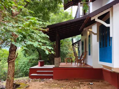 a front porch of a house with a tree at Seethavanam Farmstay at Forest Edge in Kollengode