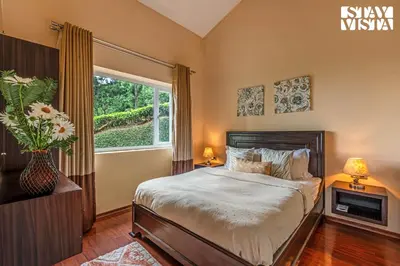 a bedroom with a large bed and a window at StayVista at Farview Suite Serenity with Lawn in Kotagiri