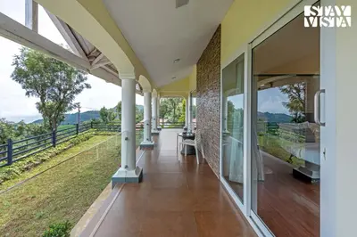 an external view of a house with glass doors and a porch at StayVista at Farview Suite Serenity with Lawn in Kotagiri