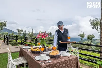an elderly man standing at a table with food at StayVista at Farview Suite Serenity with Lawn in Kotagiri