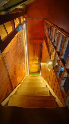 a wooden stairway with a light at the top at Madama Mudhouse Edenwood Retreats in Kanthalloor