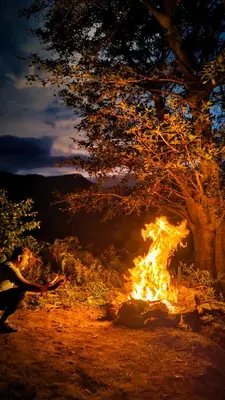 a fire is burning in a field at night at Madama Mudhouse Edenwood Retreats in Kanthalloor