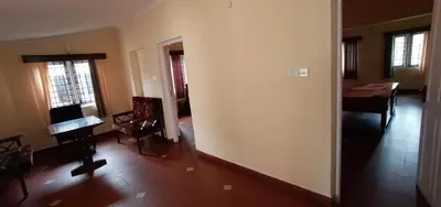 a living room with a piano and a dining room at Ooty FernCrest in Ooty