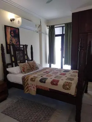 a bedroom with a bed and a window at Thambaratty in Mysore